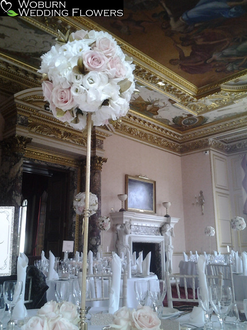 Tall stand of white Hydrangea, white Lizzianthus, Freesia, Sweet Avalanche roses and gold foliage.