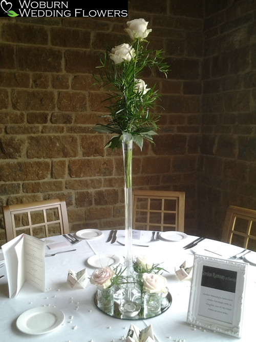 Tall slender vase of Roses and greenery with complimenting base vases