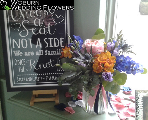 Jar arrangement of Roses, Thistle, Delphinium and Freesia.