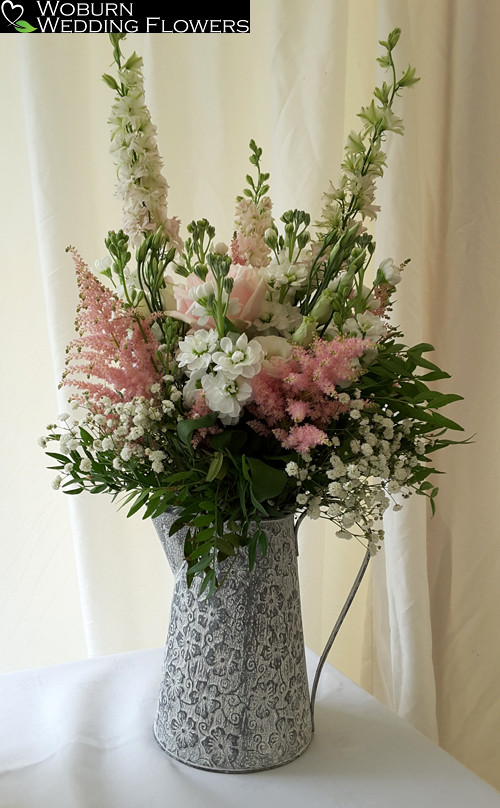 Stocks, Astilbe, Lizzianthus, Larkspur and Rose arrangement in jug.