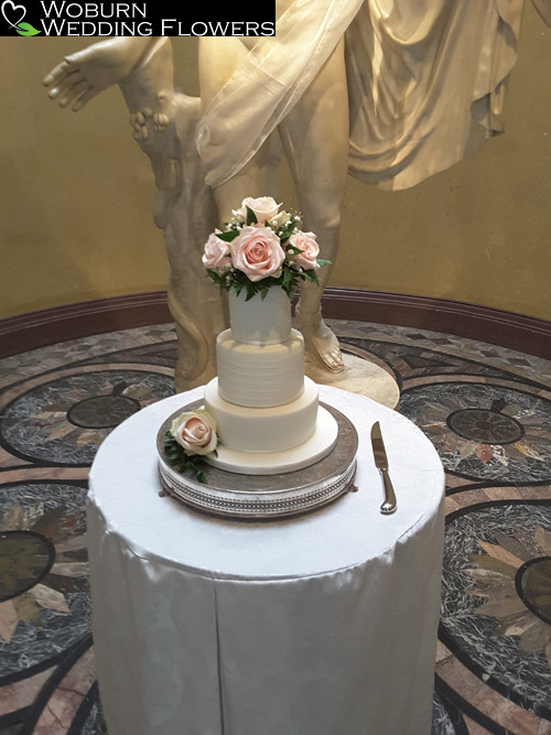 Classic blush rose cake topper in front of Apollo at Woburn Sculpture Galley.