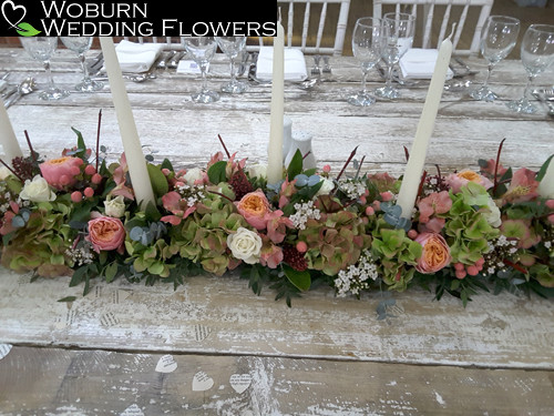 Long candle arrangement with Vuvuzela roses, Hydrangea and Gypsophillia