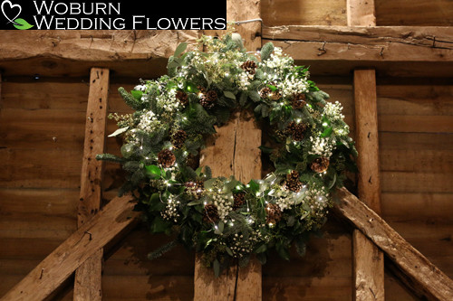 Gypsopillia and greenery wreath with pine cones and lights.