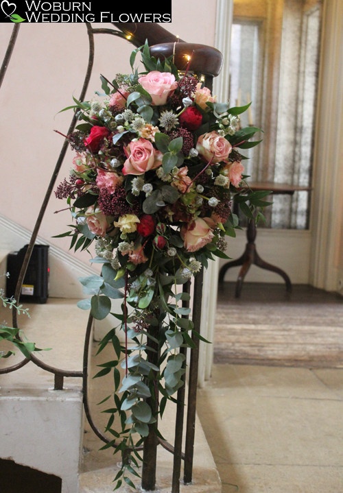 Newel post of upper secret and piano roses, skimmmia, lizzianthus, cornus and eucalyptus.