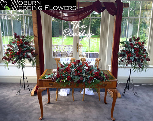 Black Baccara Roses, Clove Carnations, Skimmia, Dusty Miller, Alstromeria, Gypsophilia and Eucalyptus arrangements.