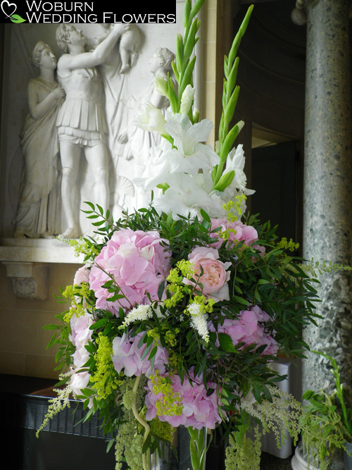 Gladioli, delphinium and astible tall vase near the Apollo end