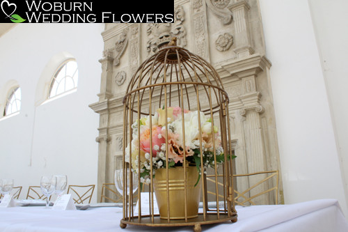 Coral, white and gold bird cage in the Orangery.