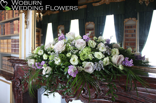 Soft lilac and green mantelpiece arrangement.